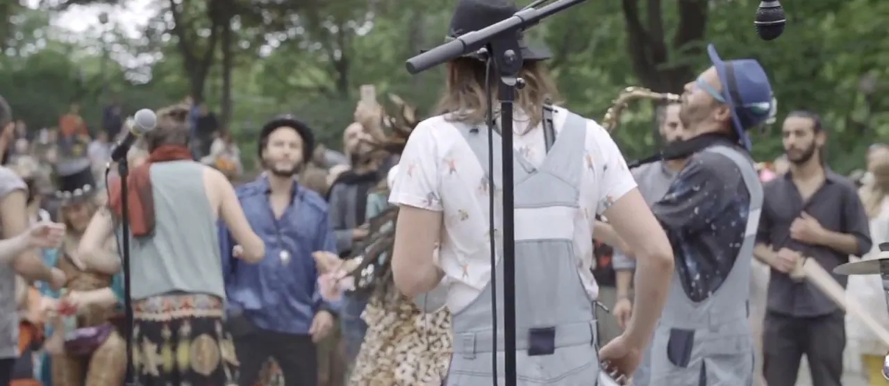 Stillbild ur livevideon där Bicycle Beat spelar bland publik utomhus.